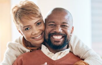 Happy, love and portrait of black couple on sofa for relax, retirement or support together. Smile, hug or marriage with old man and woman in living room at home for bonding, relationship or lifestyle